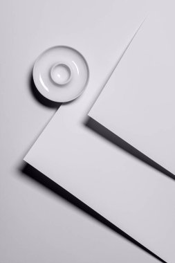 Beyaz kağıt üzerinde boş porselen yuvarlak yumurta standı olan modern soyut minimalist arka plan. Gölgeli geometrik şekiller ve arka planda kağıt dokusu. Uzayı kopyala Doğrudan yukarıdan görüntüle.