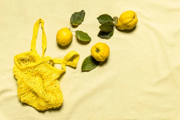 Tres Manzanas Membrillo Con Hojas Bolsa Malla Amarilla Sobre Fondo — Foto de Stock