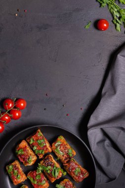 Domates soslu lahana rulosu ve siyah tavada doğranmış maydanoz, kiraz domatesleri, dikey siyah desenli taş zemin üzerinde keten peçete yemeye hazır bir şekilde yatıyordu. Boşluğu kopyala.