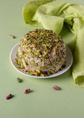 Şam fıstıklı susam halkası, birkaç dağınık fındık ve yeşil kağıt üzerine yeşil keten peçete. Yüksek açı. Geleneksel Orta Doğu tatlıları. Yahudi, Türk, Arap ulusal tatlısı.