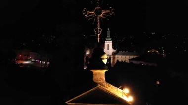 Şehrin üzerindeki antik kilisenin haçı. Lviv, Ukrayna 'daki St. Andrew Katolik Kilisesi. Şehrin gece manzarası. Hava aracı görüntüsü, vinç görüntüsü 