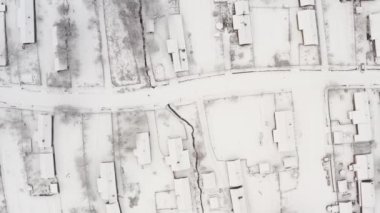 Kuş bakışı karla kaplı köy manzaralı. Kar ve az buz olan güzel kış havası. Kulübelerde kar, bahçeler, ağaçlar, toprak yol vs. Hava İHA 'sı tepemizde.