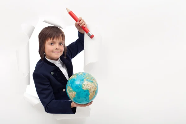 Schoolboy with large pencil and earth globe — Stock Photo, Image