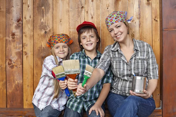 Frau mit Kindern bereit, den Schuppen zu streichen — Stockfoto