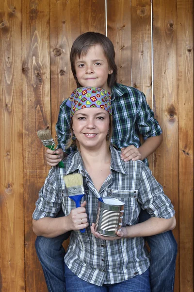 Pojken att hjälpa sin mor målning verktyget skjul — Stockfoto