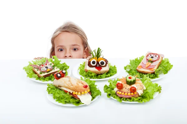 Menina olhando para criaturas criativas de comida — Fotografia de Stock