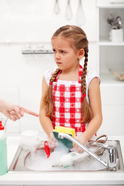 Niña enfurruñada lavando los platos —  Fotos de Stock