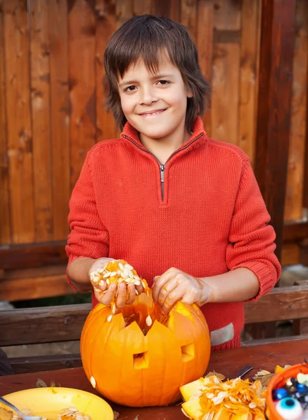 Primo piano di ragazzo intaglio Halloween jack-o-lanterna — Foto Stock