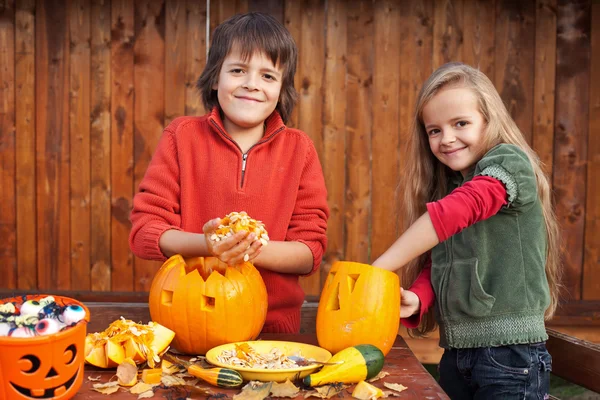 Crianças esculpindo suas abóboras jack-o-lanternas — Fotografia de Stock