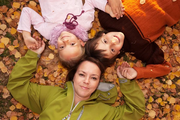 Frau mit Kindern auf dem Herbstboden — Stockfoto