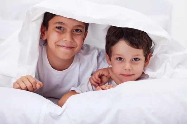 Los hermanos jóvenes juntos - los muchachos bajo la manta — Foto de Stock