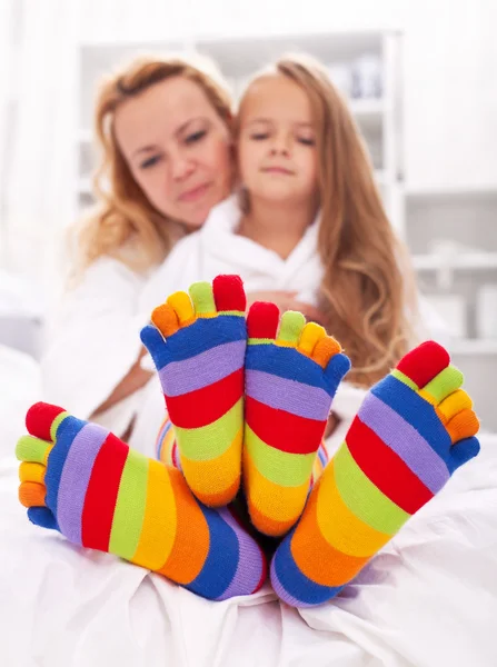 Woman and little girl wearing funny socks — Stock Photo, Image