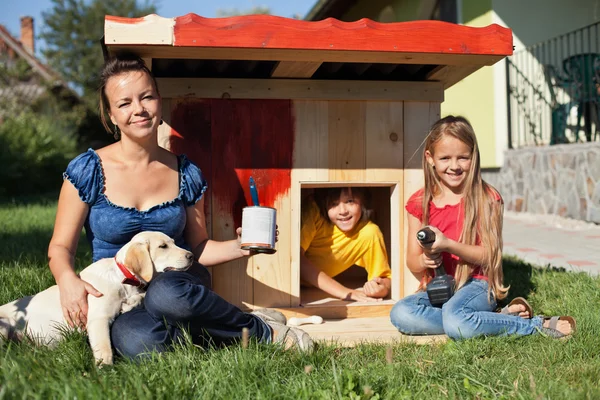 Happy kids painting the doghouse — Stock Photo, Image