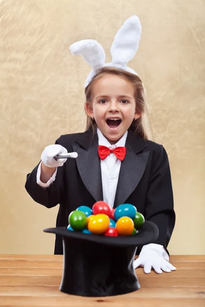 Felice mago ragazza evocando uova di Pasqua colorate — Foto Stock