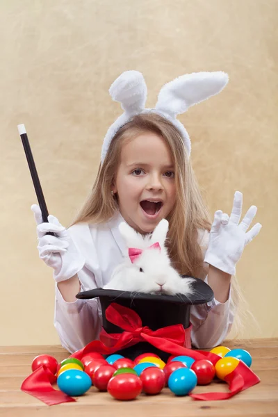 Little magician girl conjuring easter items — Stock Photo, Image