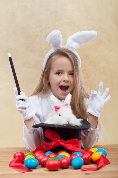 Kleines Zaubermädchen zaubert Osterartikel — Stockfoto