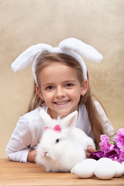Szczęśliwa dziewczynka z bunny uszy i jej ładny biały królik — Zdjęcie stockowe