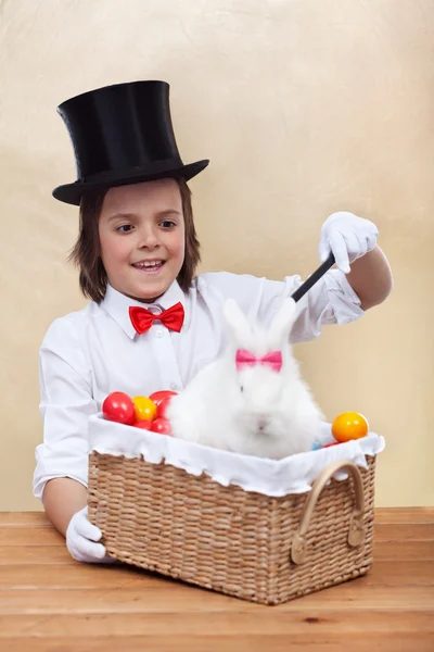 Feliz mago conjurando un conejo de Pascua y huevos coloridos —  Fotos de Stock