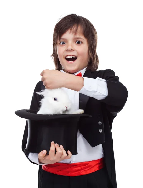 Young magician boy taking a rabbit out of his hat — Stock Photo, Image