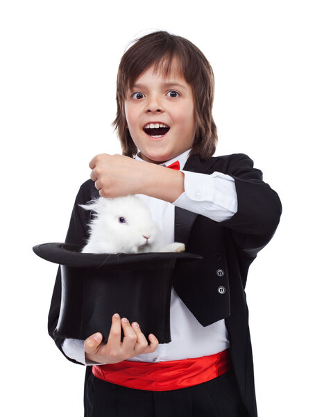 Young magician boy taking a rabbit out of his hat
