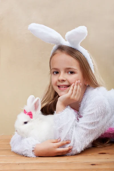 Glückliches Mädchen im Hasenkostüm mit ihrem weißen Kaninchen — Stockfoto
