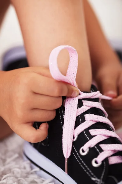 Closeup on child hands as they tie shoes-shallow depth of field