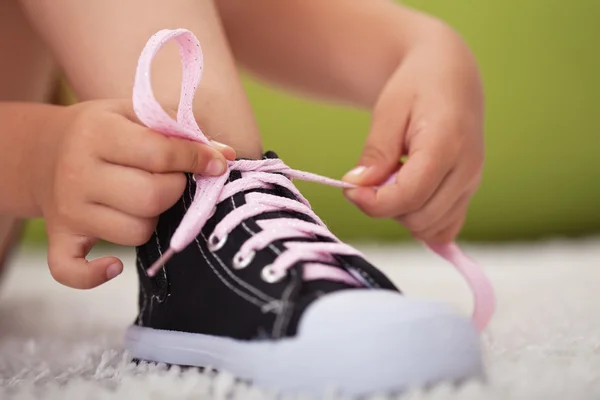 Young girl hands tie shoe laces-shallow depth of field