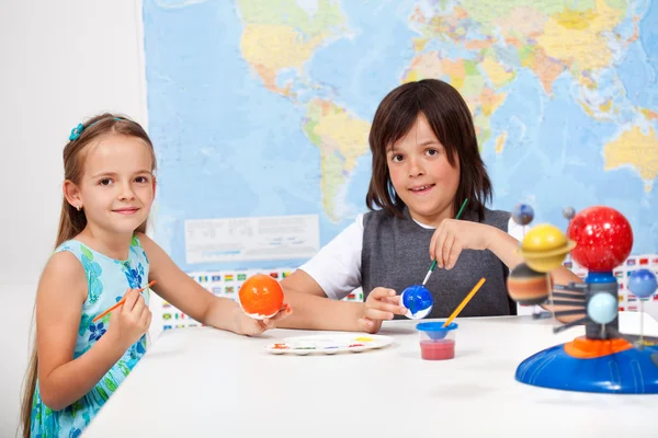 Kids in science and arts class - painting the scale model of the — Stock Photo, Image