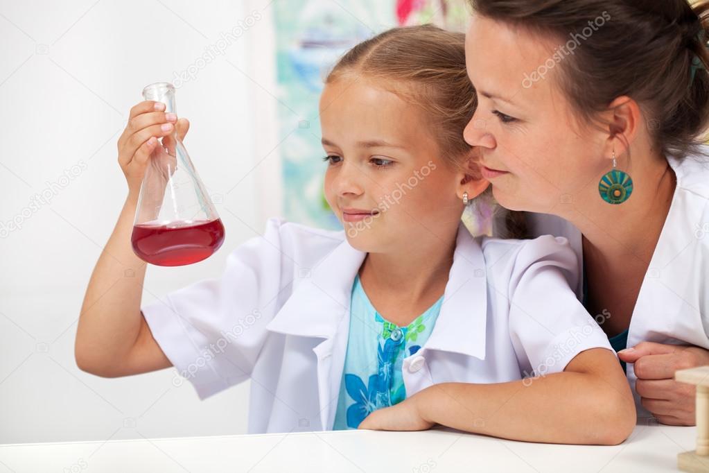 Young student girl in chemistry class with her teacher