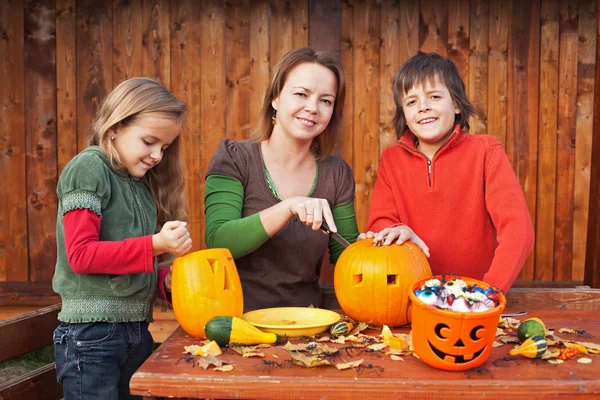 Familie schnitzt Kürbislaternen für Halloween — Stockfoto