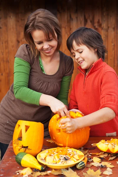 Menino e mulher esculpindo uma jack-o-lanterna — Fotografia de Stock