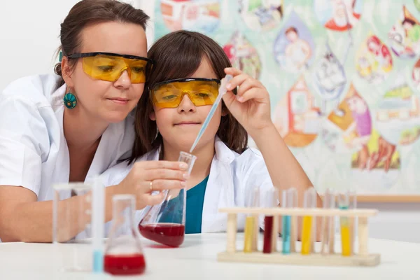 Niño en la clase de ciencias primarias haciendo experimento químico — Foto de Stock