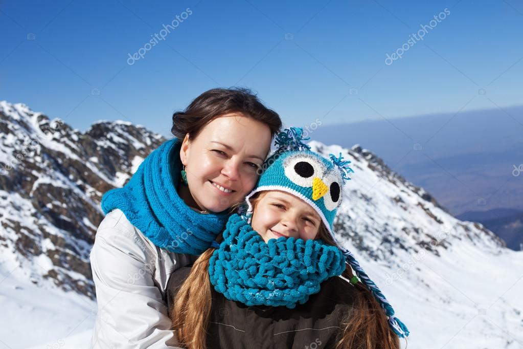 Woman and little girl portrait on a mountain top