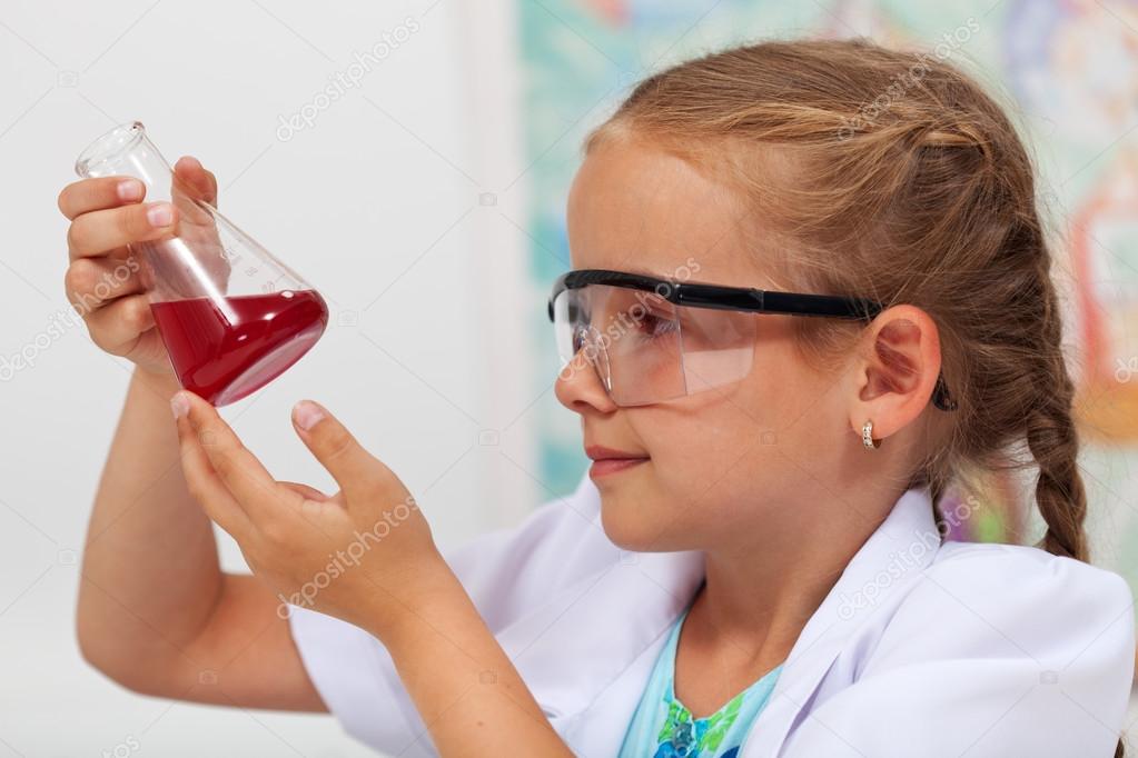 Young girl in chemistry class checking the result of an experime