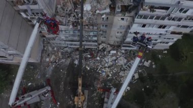 İtfaiyeciler yıkılmış evdeki gaz bombası patlamasından sonra insanları bulmaya çalışıyorlar.