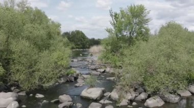 Yeşil ağaçların ve vahşi nehirdeki büyük kayaların arasında drone uçakları.