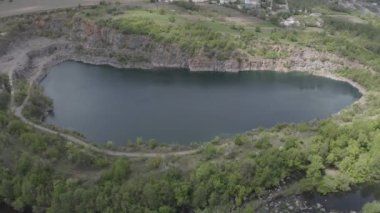 Çevresinde bir sürü yeşil ağaç olan granit ocağı gölü.