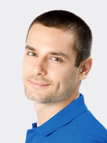 Sonriente joven atractivo hombre, contra gris —  Fotos de Stock