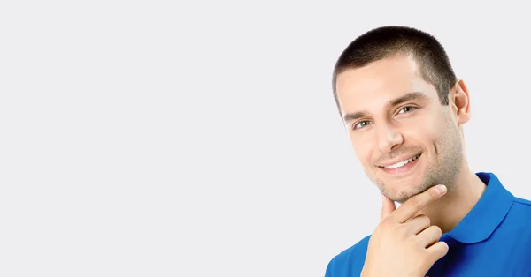 Sonriente joven atractivo hombre, contra gris —  Fotos de Stock