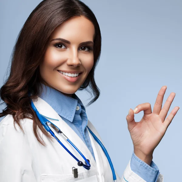 Fiatal női orvos mutatja rendben kéz jel, szürke — Stock Fotó