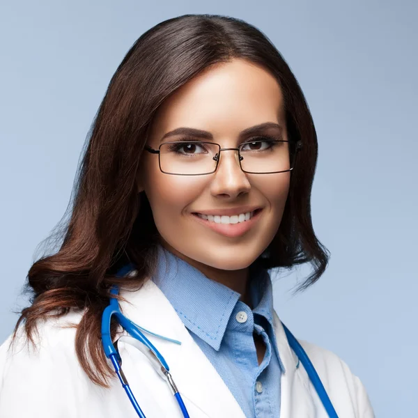 Jeune médecin en lunettes, sur gris — Photo