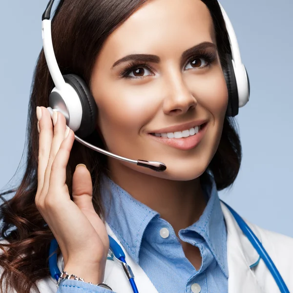 Happy smiling doctor in headset, on grey — Stock Photo, Image