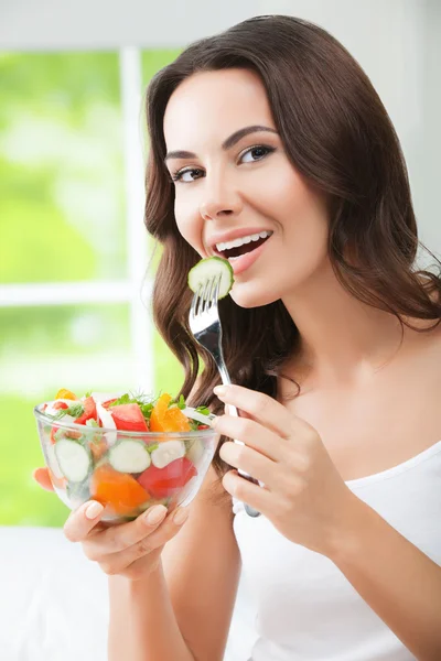 Mooie vrouw eten Salade, binnen — Stockfoto