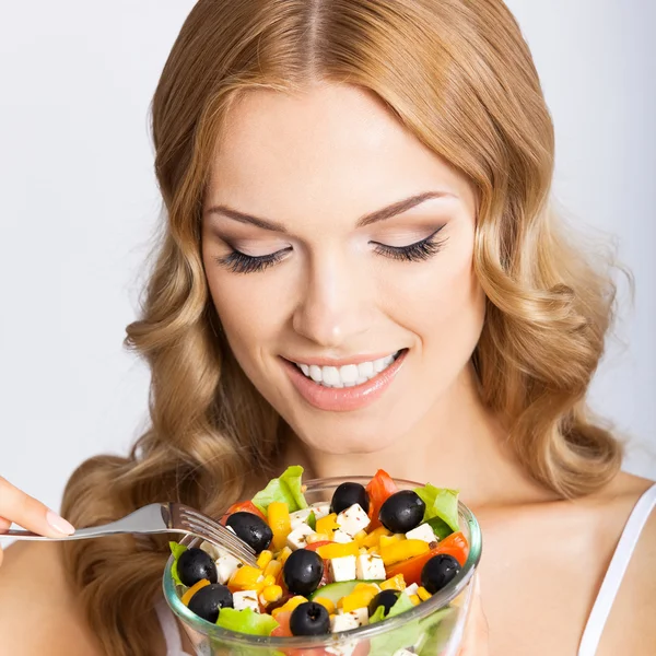 Vrouw met vegetarische salade, over grijs — Stockfoto