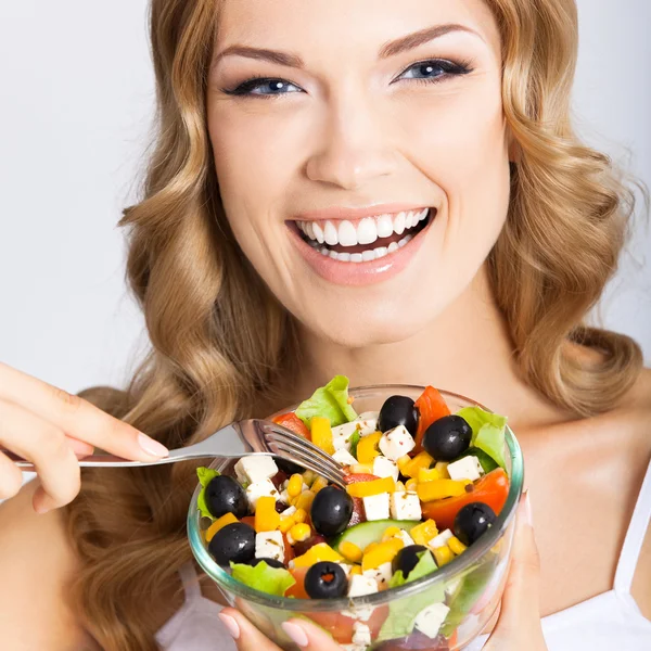 Femme avec salade végétarienne, sur gris — Photo
