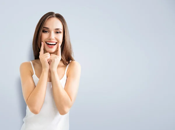 Jovem mulher mostrando sorriso, com copyspace — Fotografia de Stock