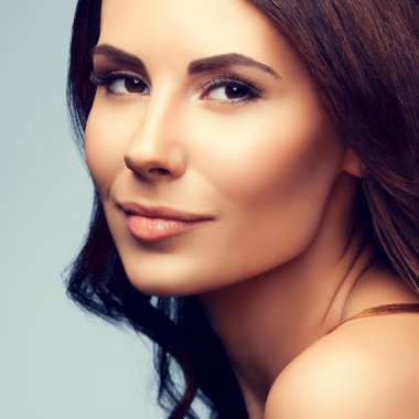 güzel genç kadın çıplak omuzlarına gri arka plan ile