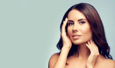 güzel genç kadın çıplak omuzlarına gri arka plan ile