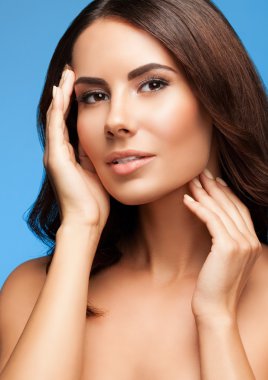 oung woman with naked shoulders, on blue