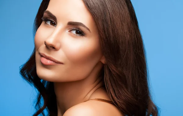 Portrait of beautiful young woman with naked shoulders, on blue — Stock Photo, Image